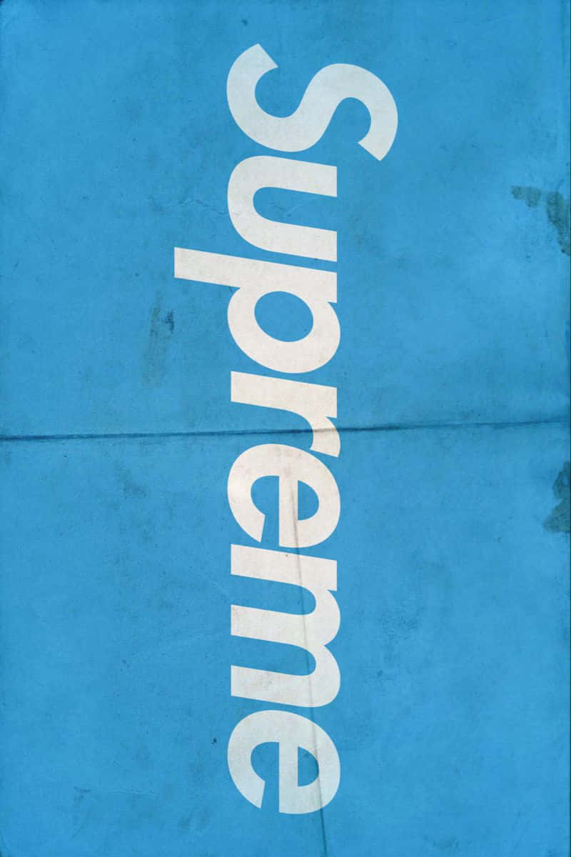blue supreme 桌布 壁紙 — 大膽的白色 'Supreme' 標誌斜向橫跨帶有皺摺和污漬的紋理藍色背景。