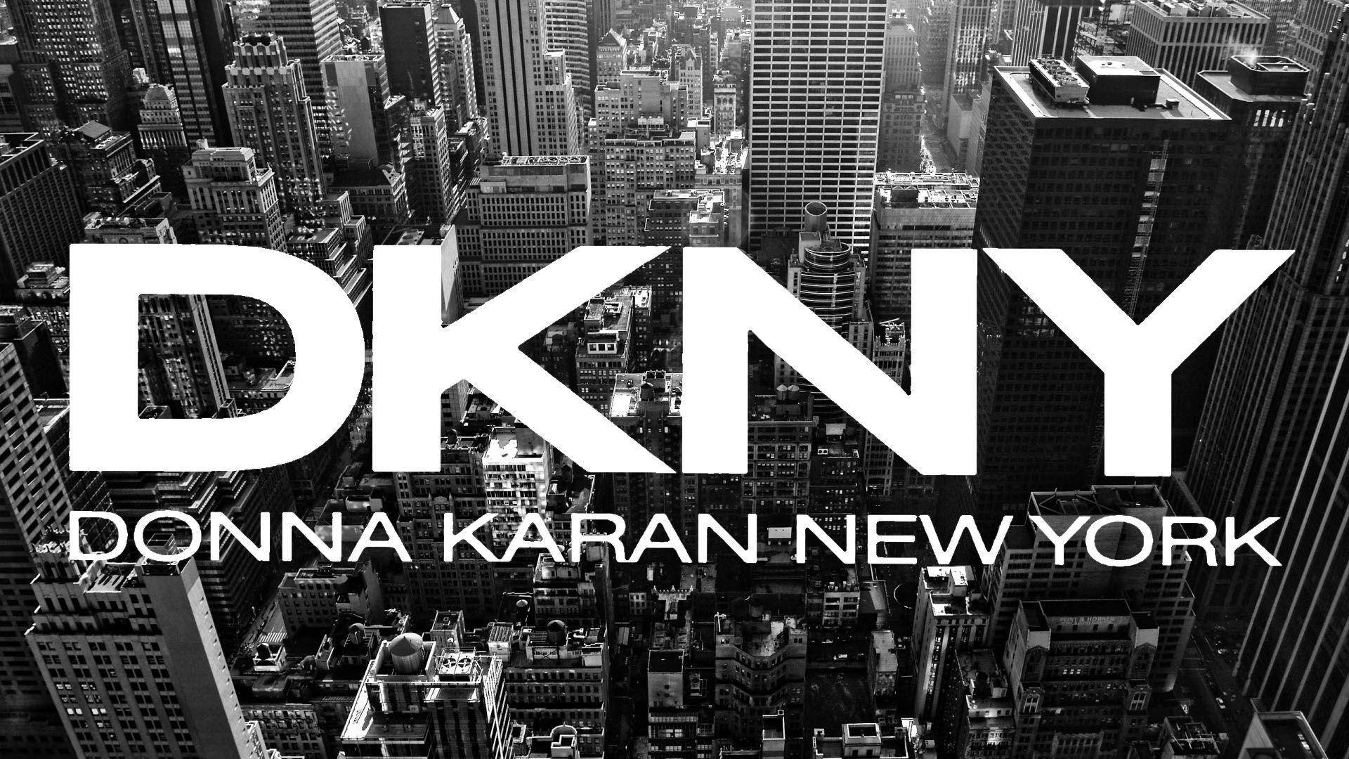 城市 桌布 壁紙 — 大膽的白色DKNY標誌疊加在高對比度的黑白密集城市天際線航拍圖上。