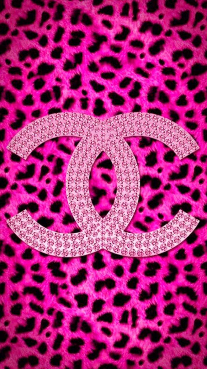 Pink Chanel Logo 桌布 壁紙 — 大膽的粉紅色豹紋壁紙，中央有閃閃發光的 Chanel 標誌，背景為毛茸茸的紋理。