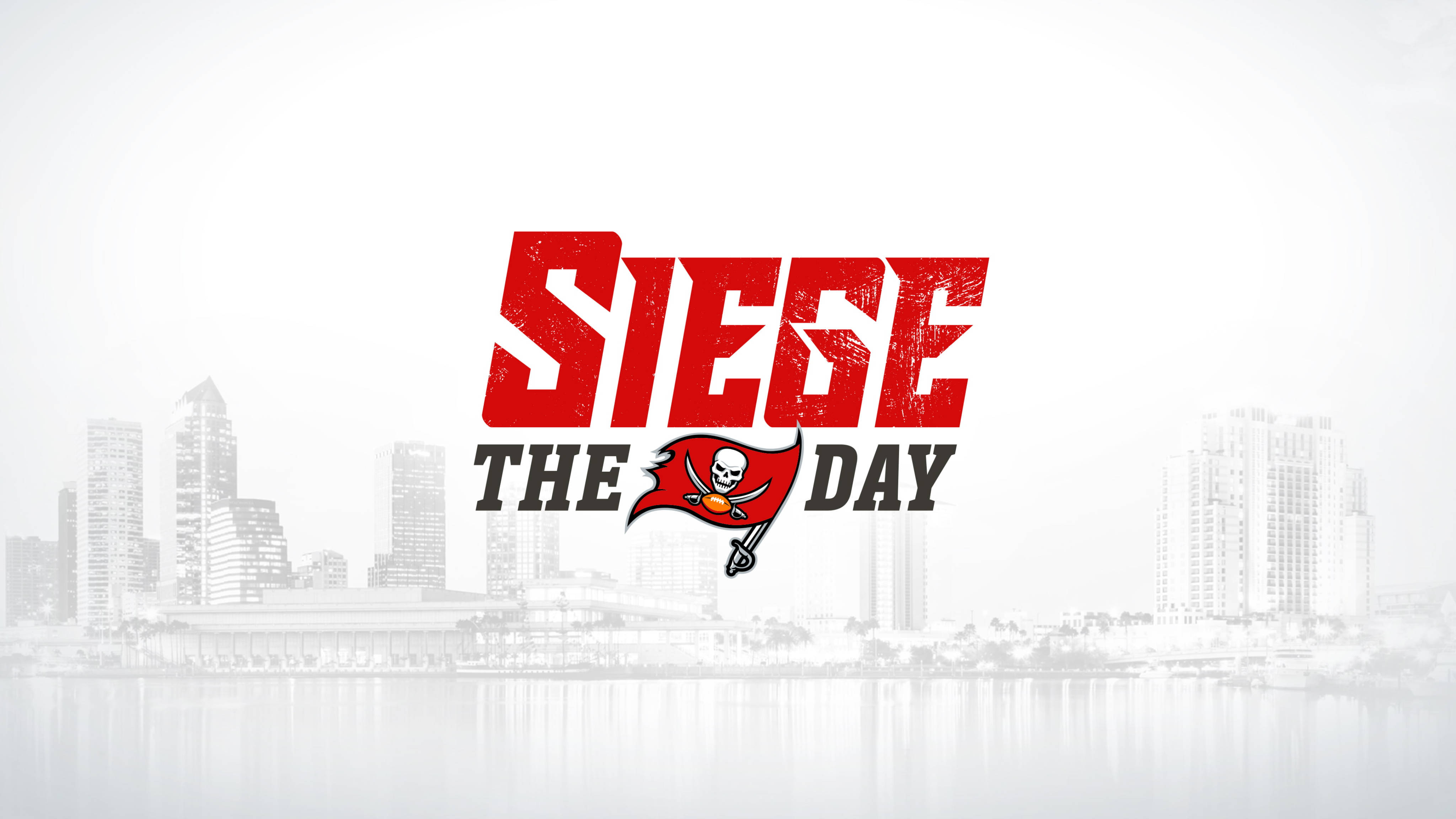 坦帕灣海盜 桌布 壁紙 — 大膽的紅色「SIEGE THE DAY」標誌，坦帕灣海盜隊旗幟居中，置於水中倒影的單色城市天際線之上。