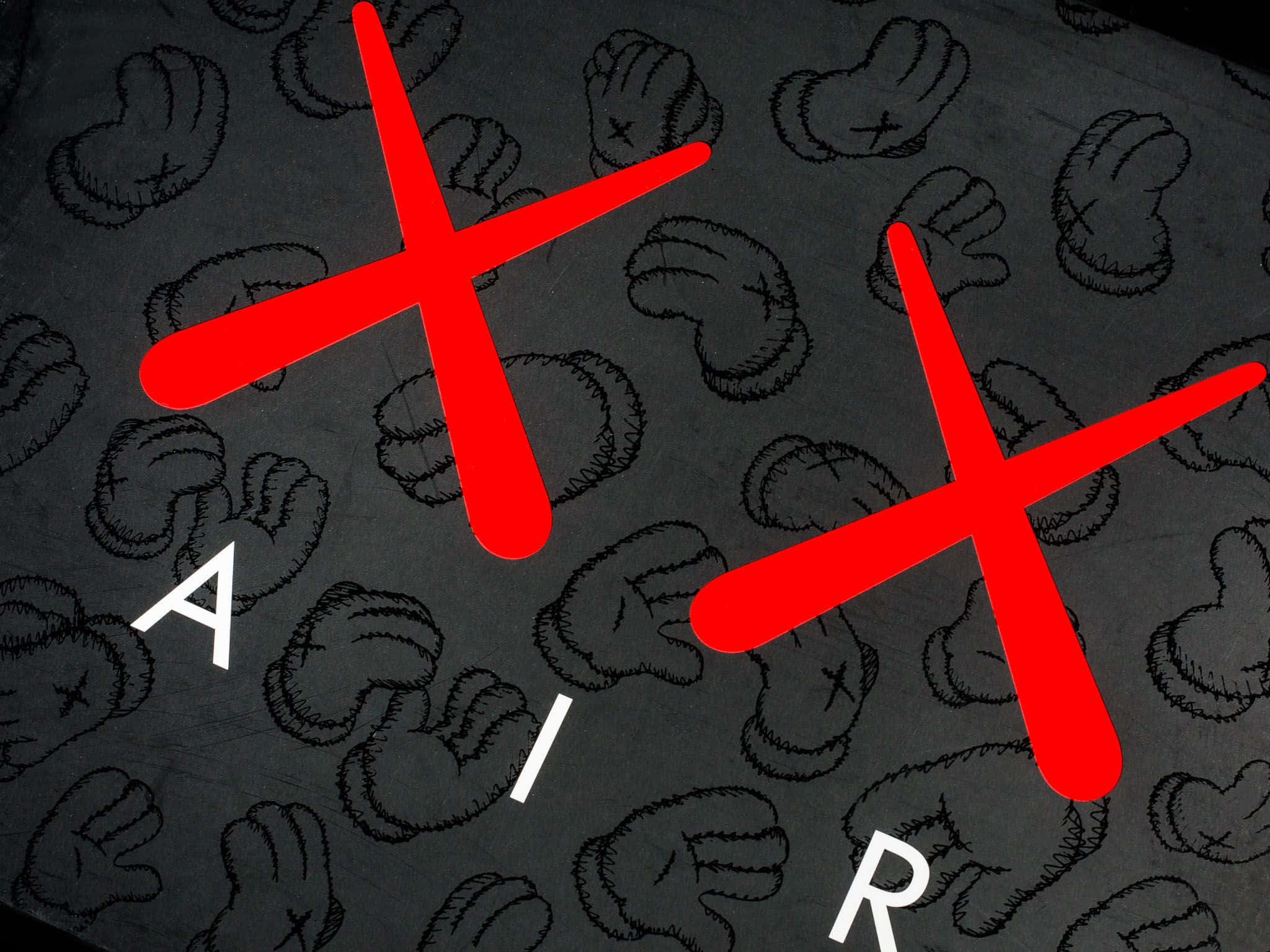 Kaws X Air Jordan 桌布 壁紙 — 大膽的紅色 X 交叉在 AIR 這個詞上，背景是深灰色，充滿了縫合手套圖案。