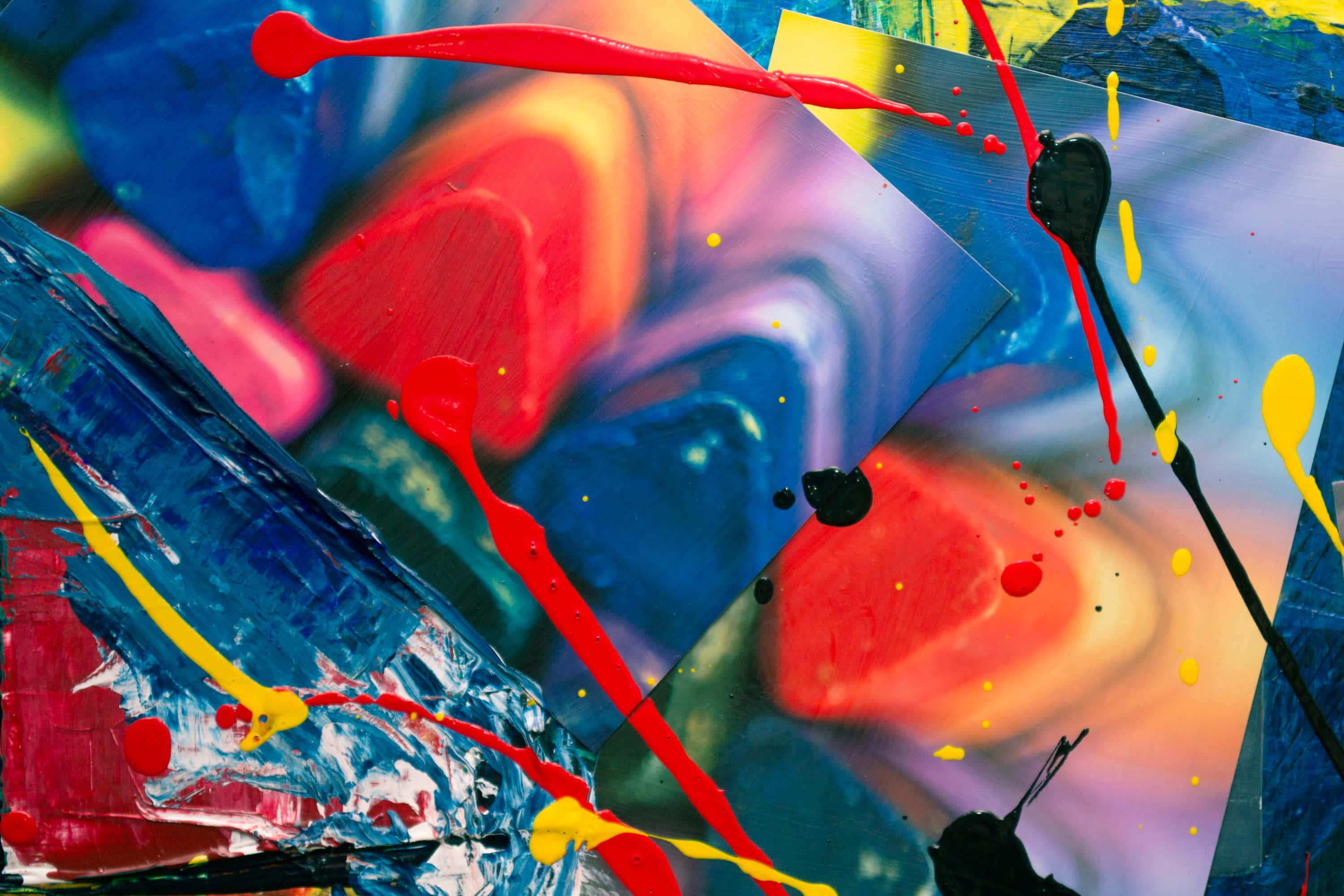 Expressionist 桌布 壁紙 — 大膽的紅色、黃色、藍色和黑色的鮮豔抽象顏料飛濺和滴落，營造出動態混亂的色彩爆炸。