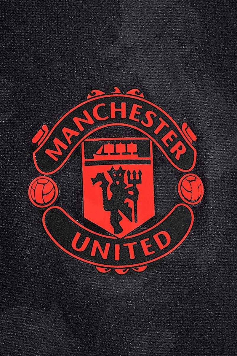 Manchester United Logo 桌布 壁紙 — 大膽的紅色曼聯會徽在質感黑色布料背景上脫穎而出。