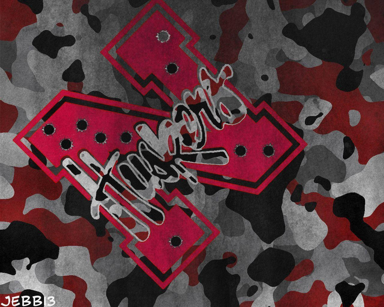 camouflage 桌布 壁紙 — 大膽的紅色箭頭帶有塗鴉文字，穿透粗糙的紅、灰、黑色迷彩圖案。
