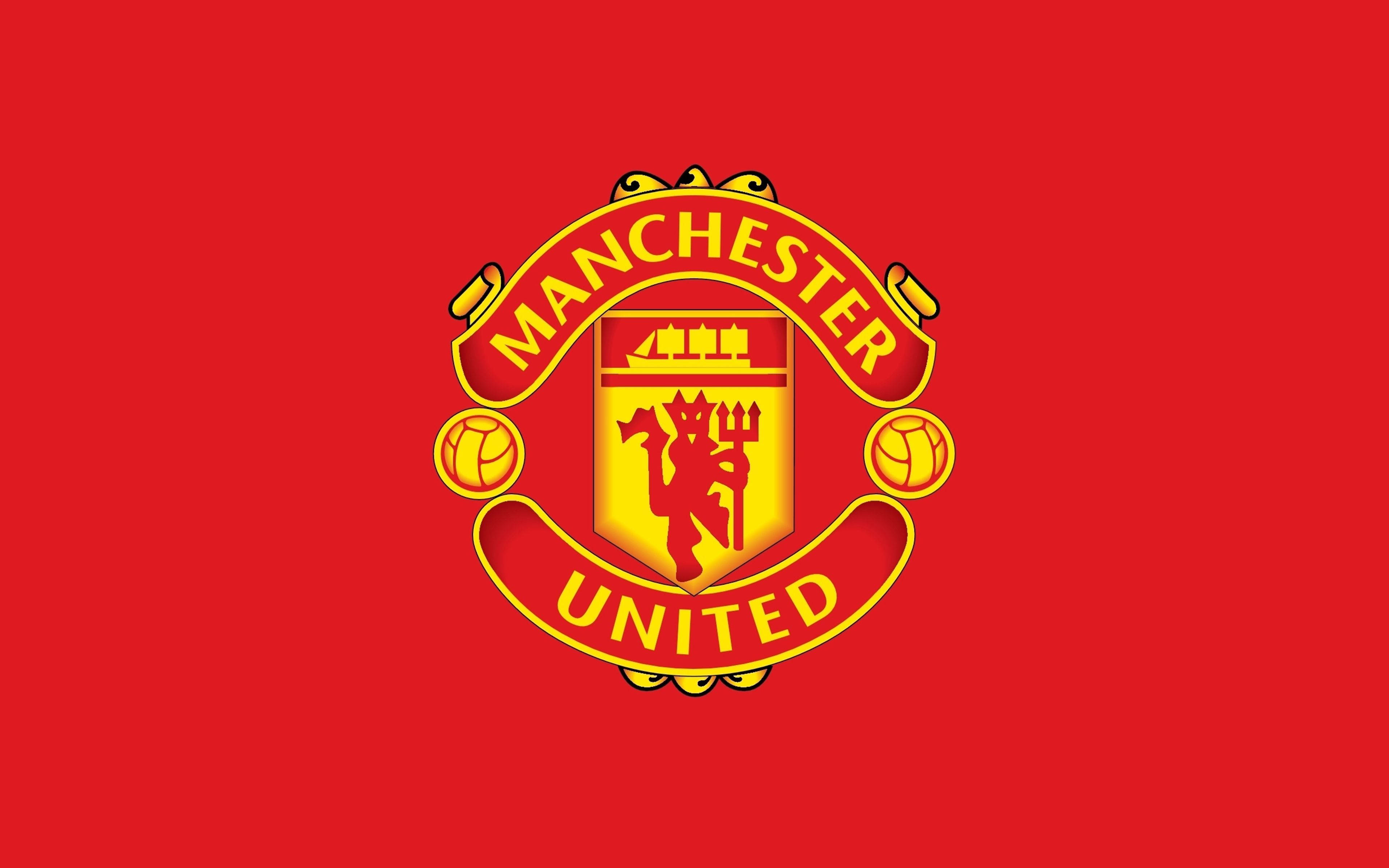 Manchester United Logo 桌布 壁紙 — 大膽的紅色背景上展示了標誌性的曼聯徽章，帶有魔鬼吉祥物和金色足球。