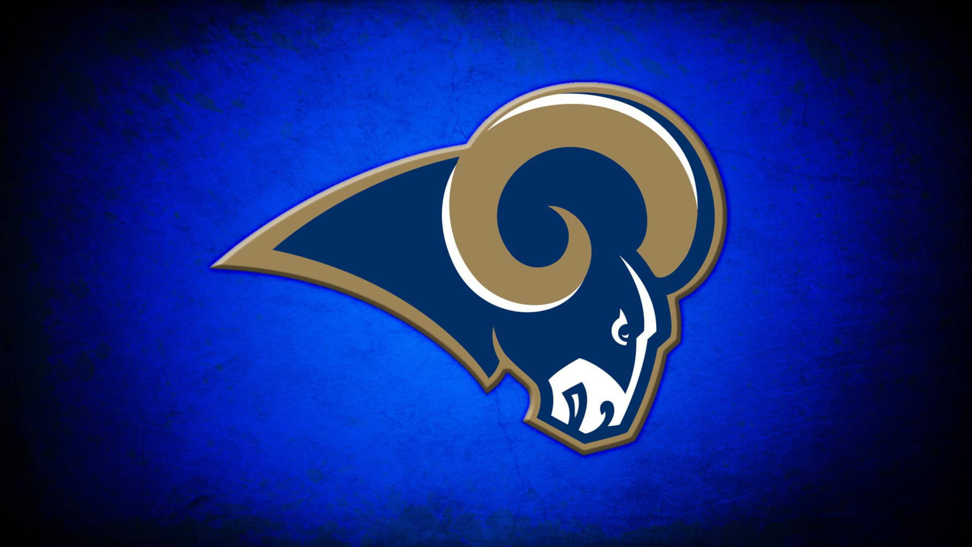 Rams 桌布 壁紙 — 大膽的藍色紋理背景上展示了NFL球隊標誌性的金色和白色公羊頭標誌。