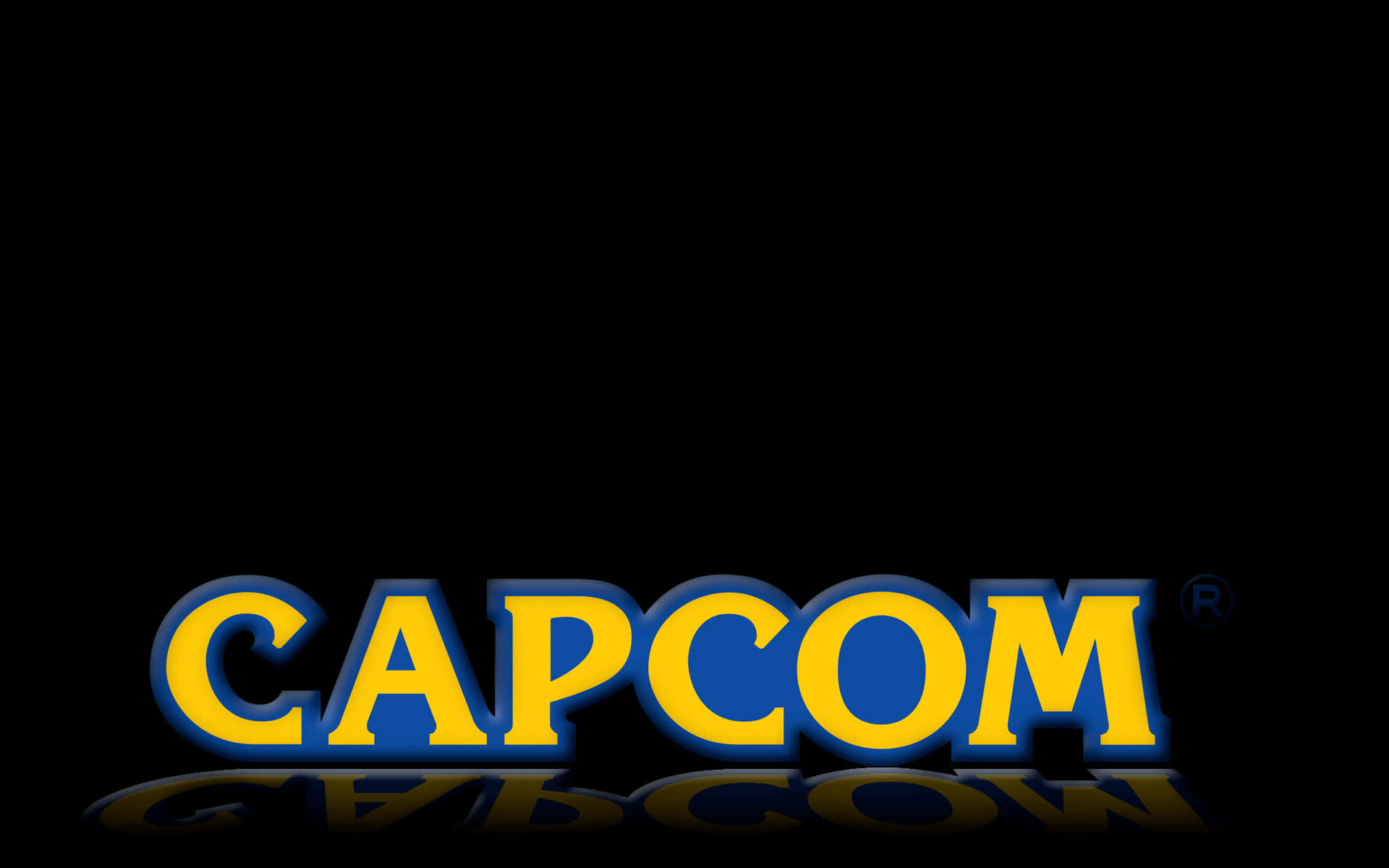 卡普空 桌布 壁紙 — 大膽的黃色和藍色 Capcom 標誌，在純黑色背景上帶有微妙的倒影。