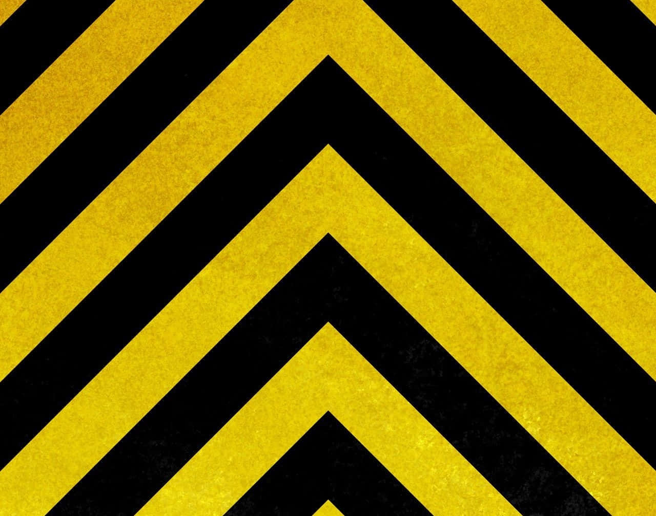 Yellow Striped 桌布 壁紙 — 大膽的黃色和黑色人字形條紋向外輻射，帶有紋理粗糙的表面。