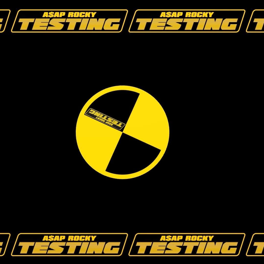 album 桌布 壁紙 — 大膽的黃色和黑色圖形，帶有重複的「ASAP ROCKY TESTING」文字，圍繞著中央的分割圓形標誌。