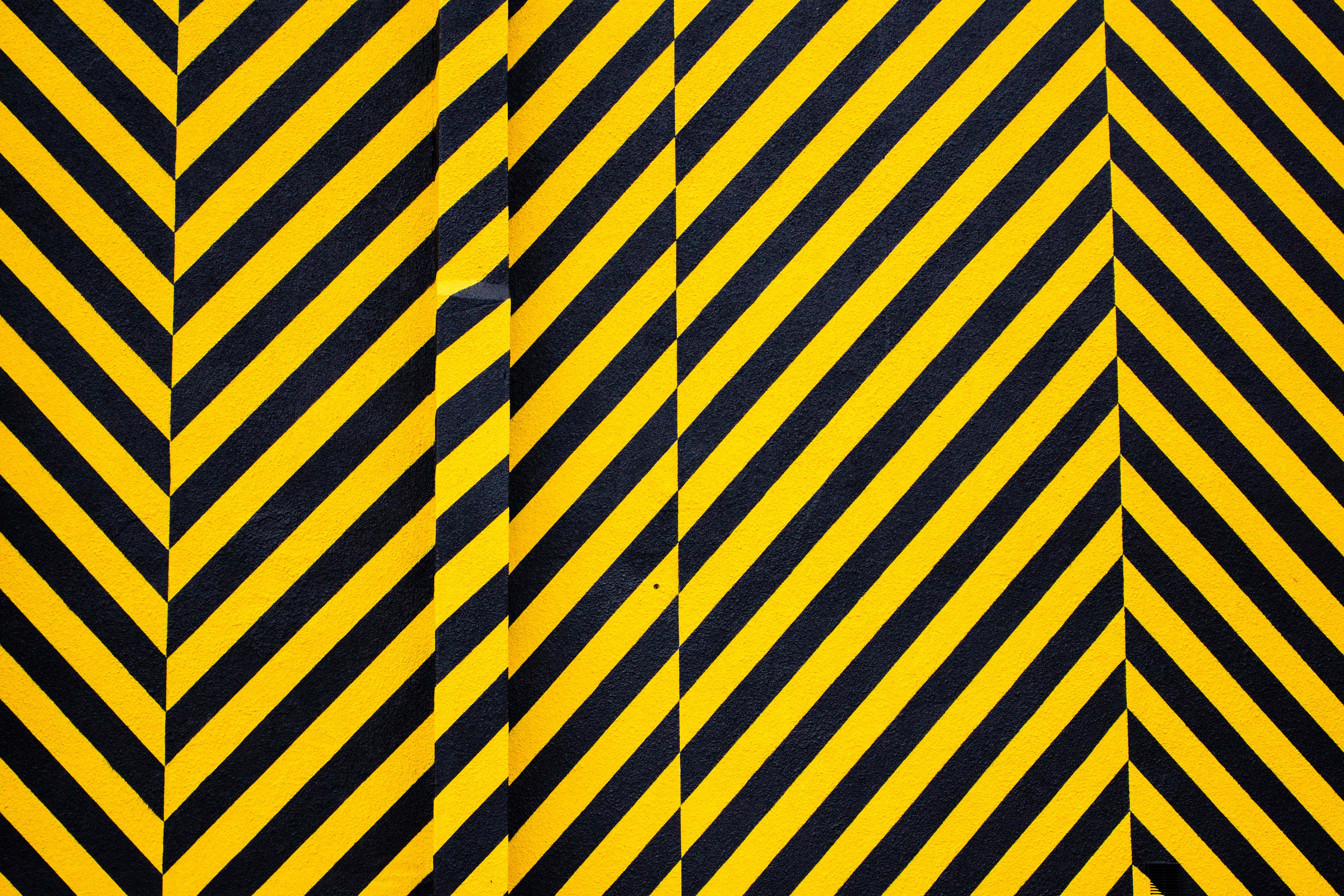 Stripes 桌布 壁紙 — 大膽的黃色和黑色對角條紋在紋理表面上形成高對比度的警告圖案。