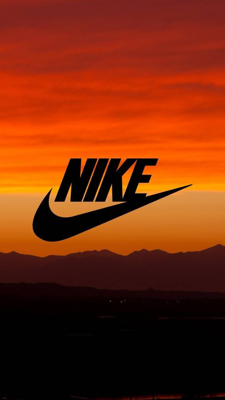 Nike iPhone 桌布 壁紙 — 大膽的黑色Nike標誌剪影，映襯著遠山之上火熱的橙紅色日落。