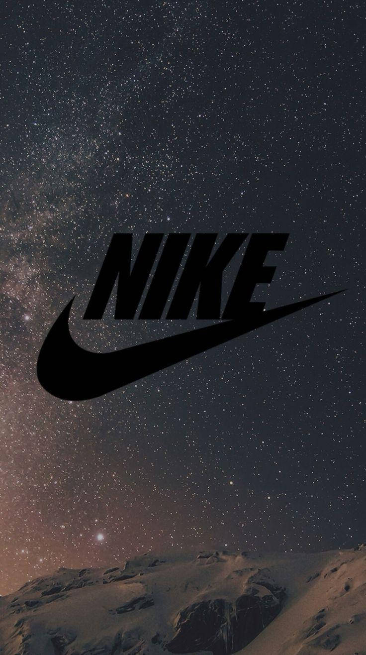 Nike iPhone 桌布 壁紙 — 大膽的黑色Nike標誌漂浮在積雪山脈上方的星空夜空之上。