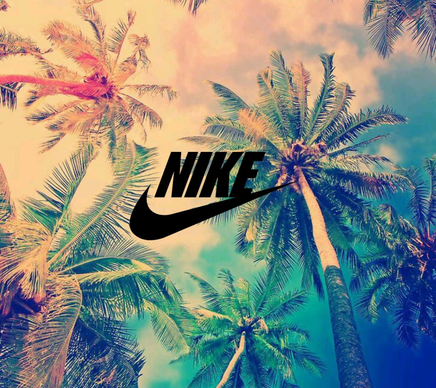 Nike 桌布 壁紙 — 大膽的黑色Nike標誌置中，襯托著充滿活力的熱帶天空，四周環繞高聳的棕櫚樹，帶有漸變日落色調。