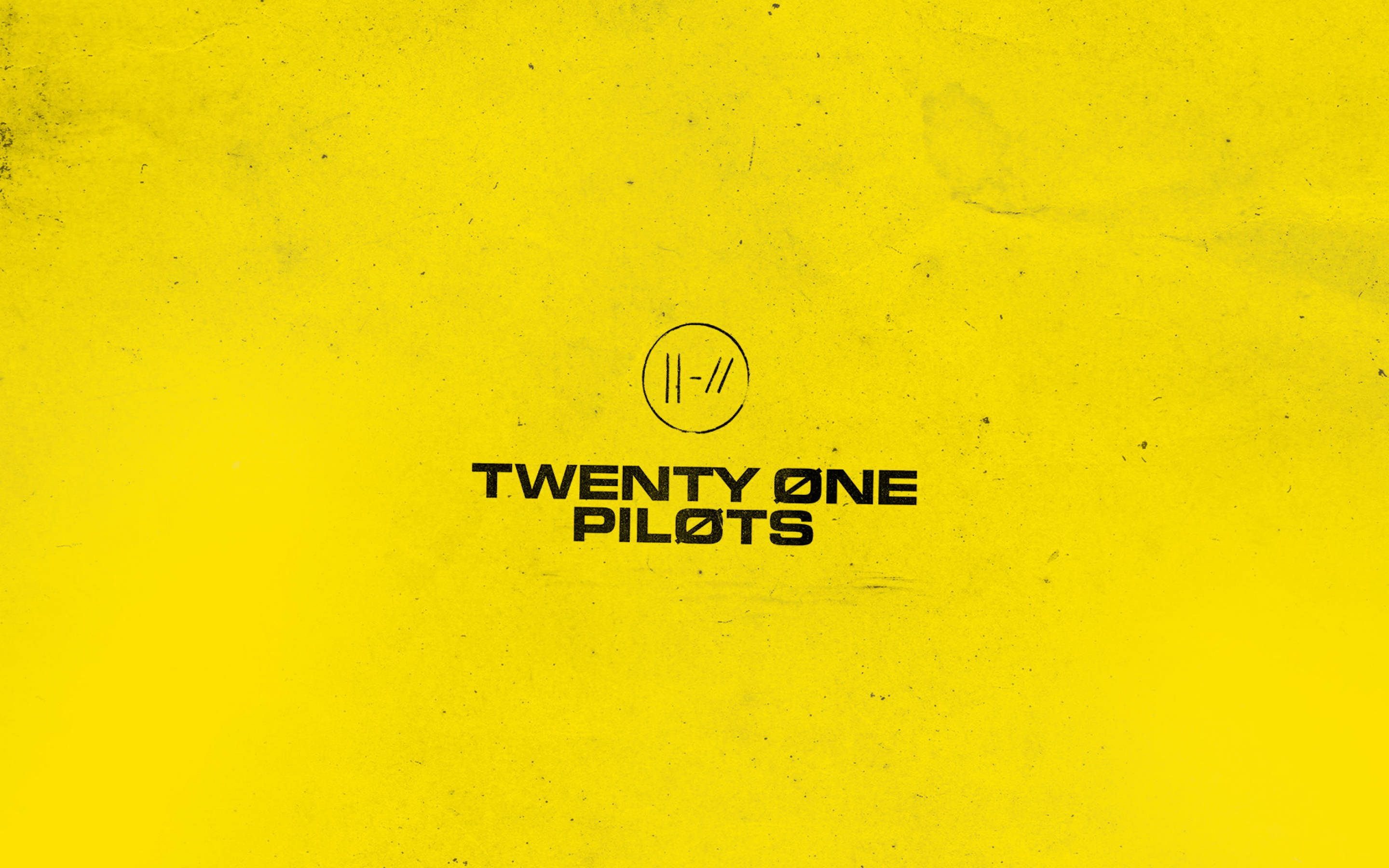 Twenty 桌布 壁紙 — 大膽的黑色Twenty One Pilots標誌居中在紋理鮮豔的黃色背景上。