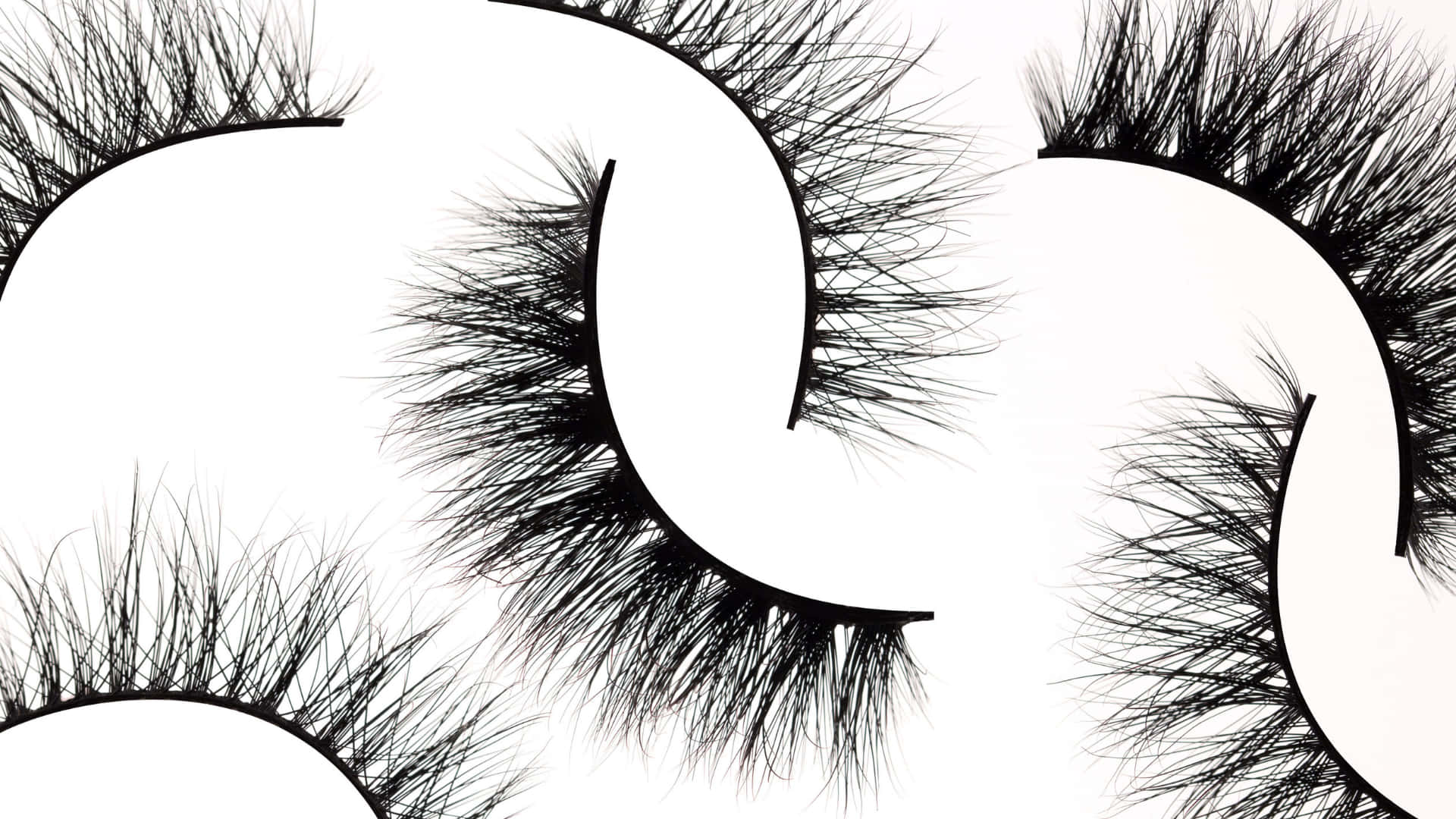 Gold Eyelash 桌布 壁紙 — 大膽的黑色假睫毛在純白背景上排列成彎曲的行。