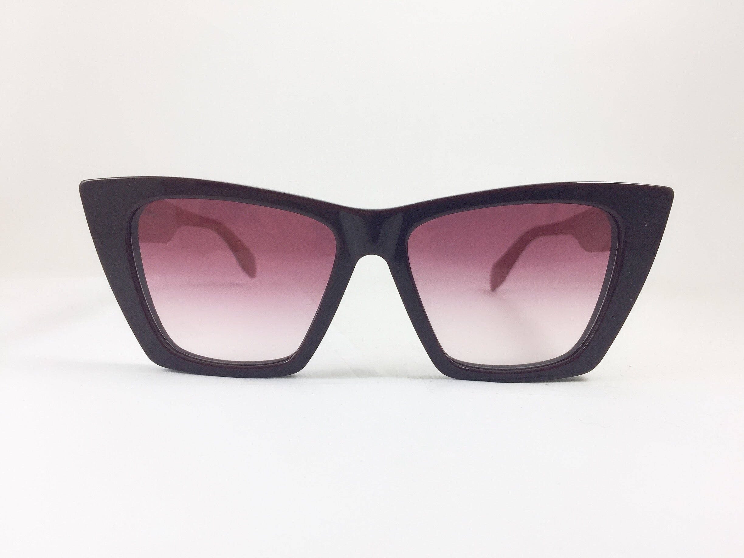 Sunglasses 桌布 壁紙 — 大膽的黑色貓眼太陽眼鏡，帶有漸變粉紅色鏡片，置於純白色背景中央。