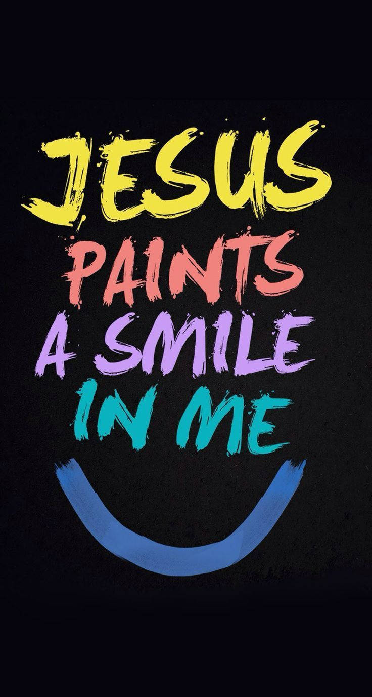 基督教 桌布 壁紙 — 大膽色彩繽紛的筆觸文字寫著 Jesus paints a smile in me，背景為黑色，下方有藍色笑臉弧線。