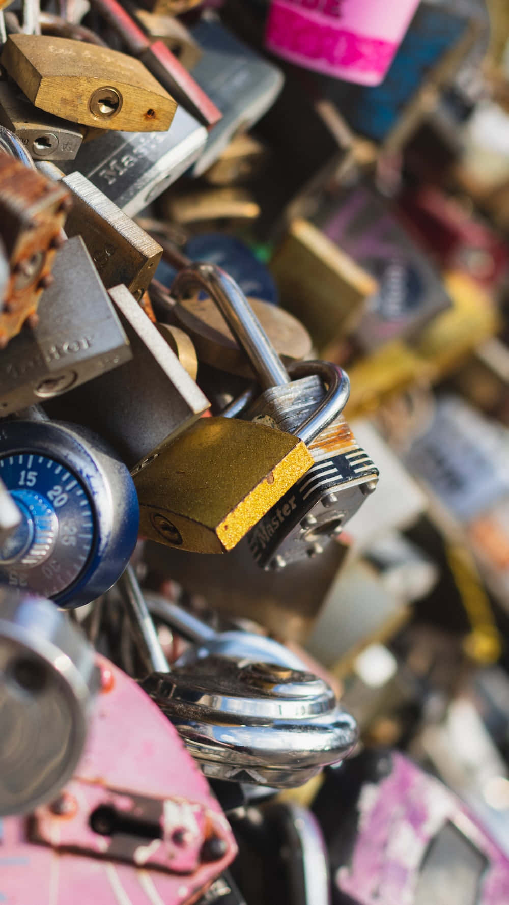 Locks 桌布 壁紙 — 大量色彩繽紛且風化磨損的掛鎖緊密堆疊在一起的近距離特寫。
