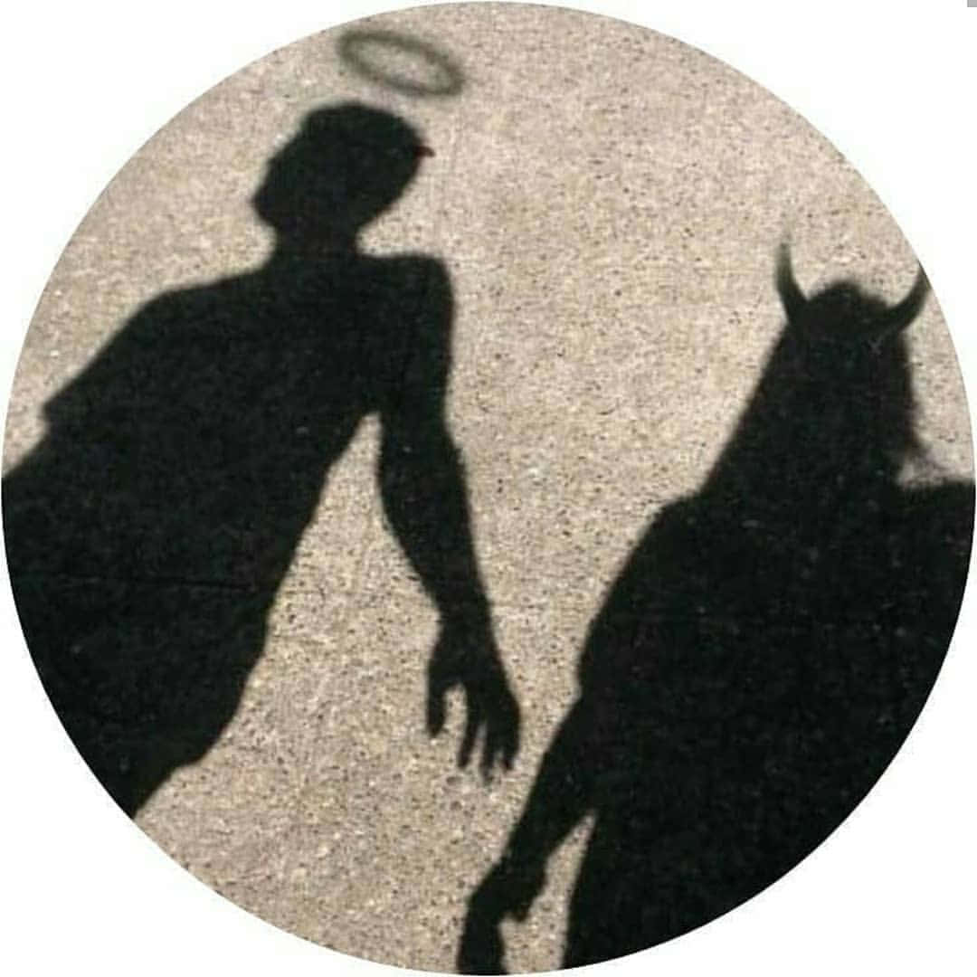 Silhouette 桌布 壁紙 — 天使與魔鬼的剪影投射在紋理地面上，在明亮光線下形成鮮明對比。
