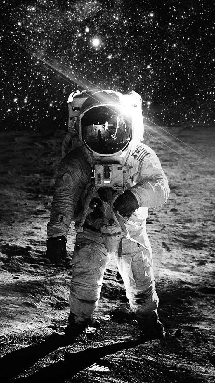 桌布 壁紙 — 太空人站在月球表面，星空下，頭盔反射中可見地球。