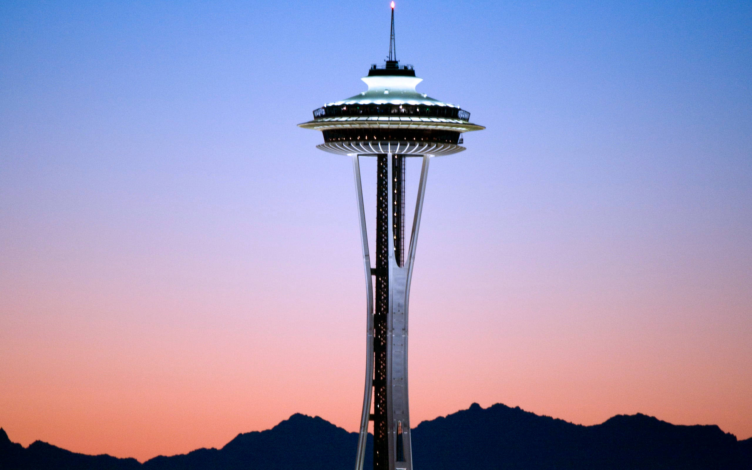 Space Needle 桌布 壁紙 — 太空針塔在暮色天空中閃耀，遠山之上呈現粉紅與藍色漸變。