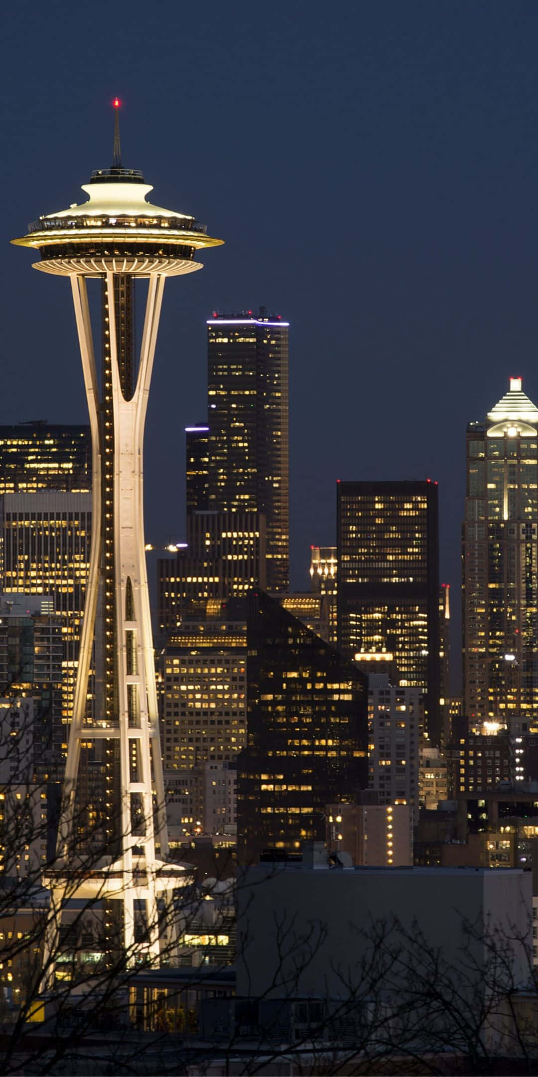 Pixel 3 Seattle 桌布 壁紙 — 太空針塔在深藍色的夜空中溫暖地發光，高聳於西雅圖燈火通明的摩天大樓之上。