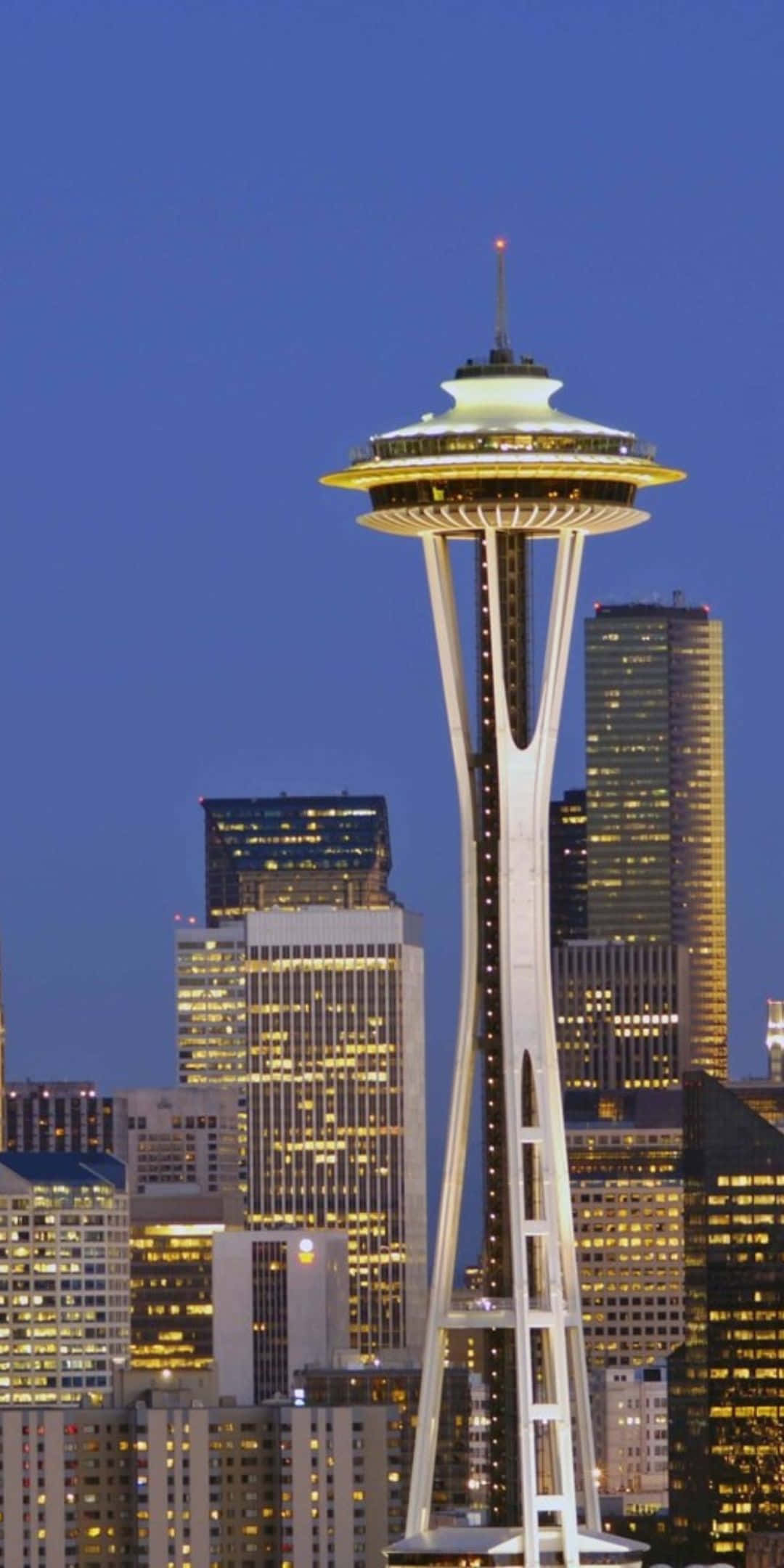 Pixel 3 Seattle 桌布 壁紙 — 太空針塔在深藍色的暮色天空中發光，城市燈光照亮了下方的西雅圖天際線。