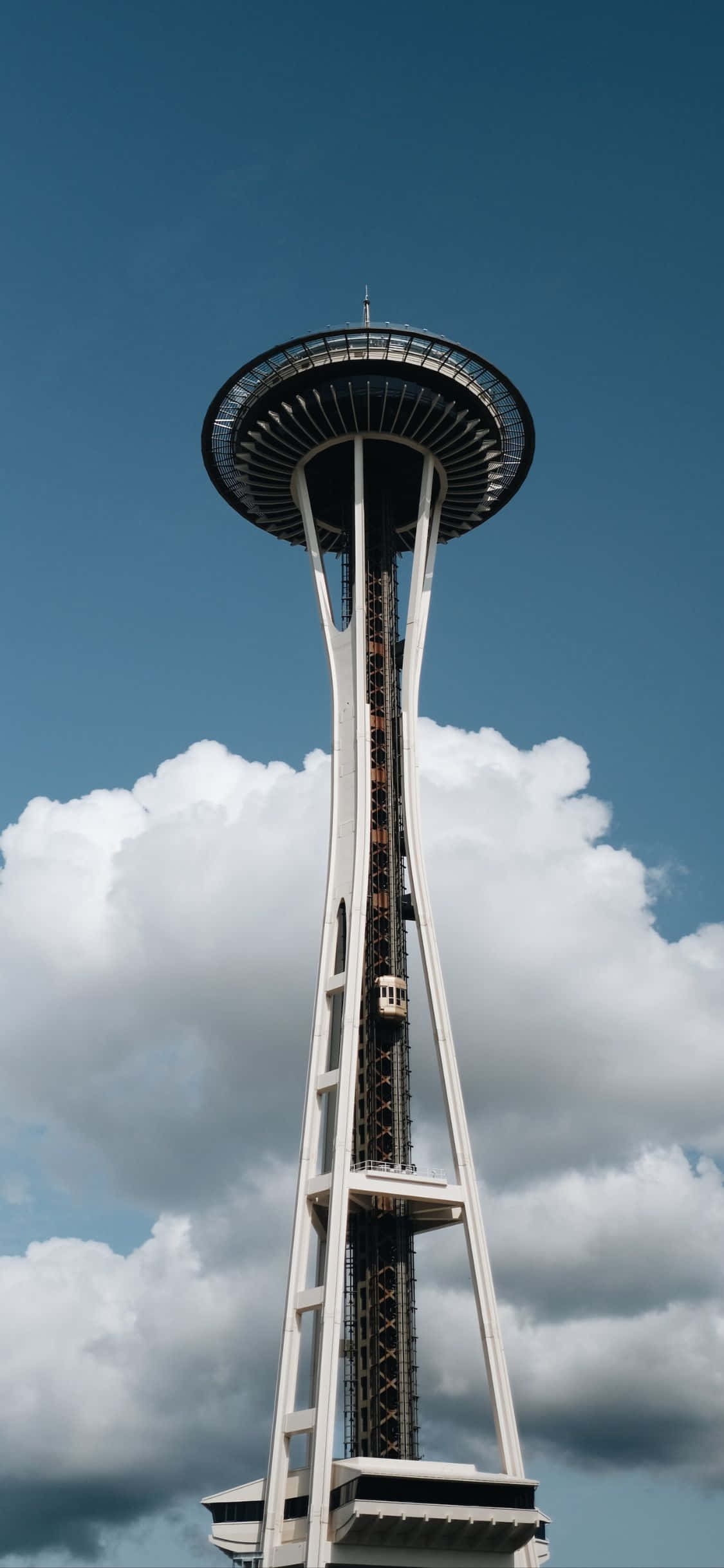 iPhone X Seattle 桌布 壁紙 — 太空針塔在西雅圖的藍天白雲下高聳入雲。