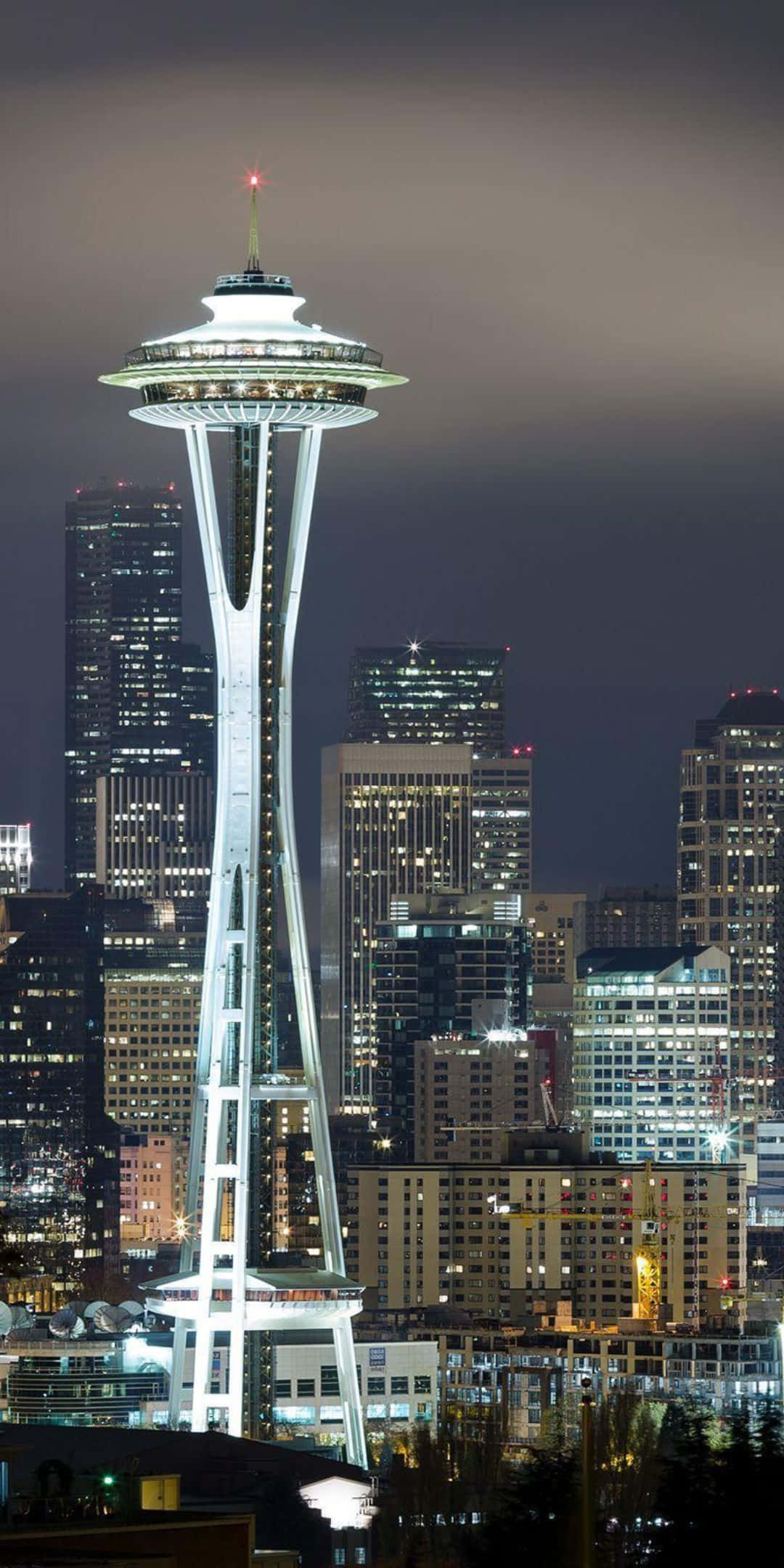 Pixel 3 Seattle 桌布 壁紙 — 太空針塔在黑暗的天空中閃耀，高聳於西雅圖夜晚燈火通明的市中心天際線之上。