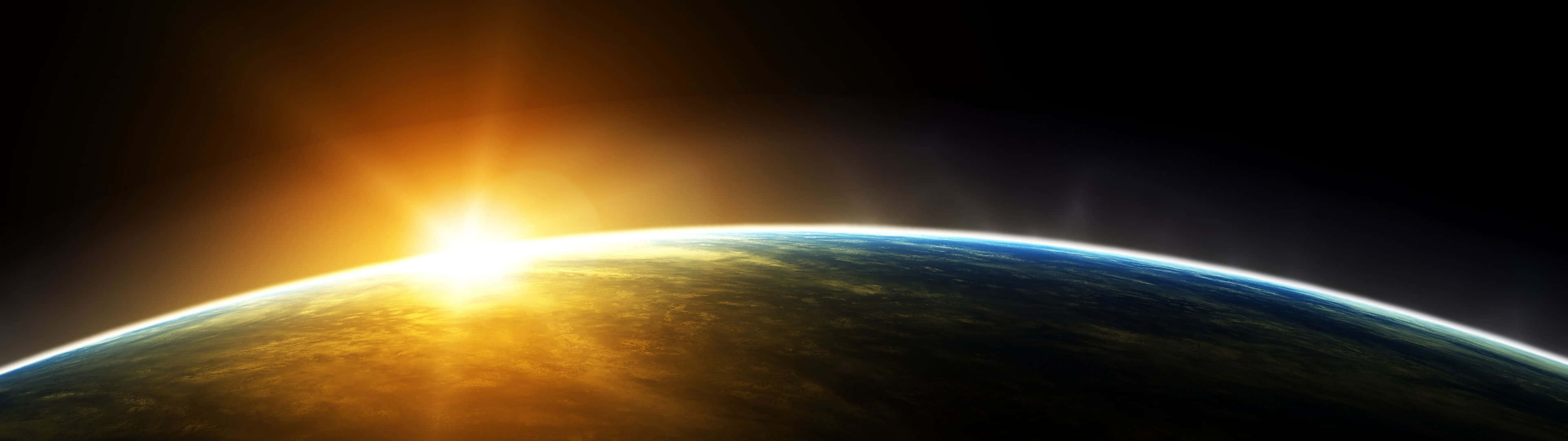太陽 桌布 壁紙 — 太陽從地球彎曲的地平線升起，在深邃的太空中閃耀著金色光芒。