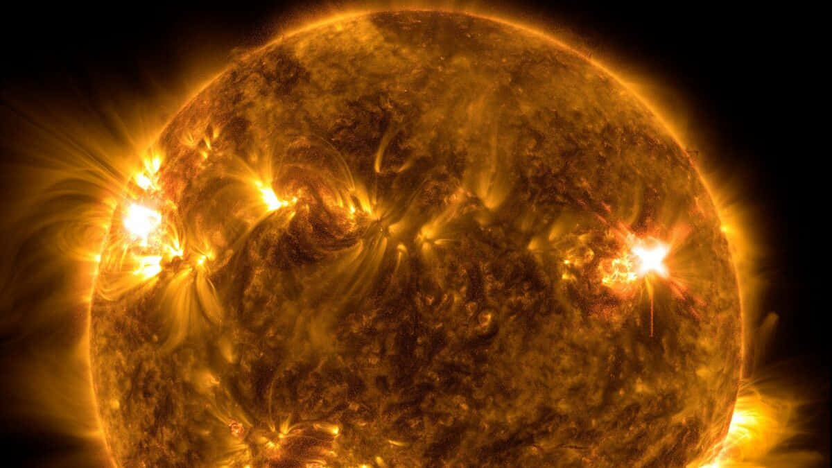 太陽 桌布 壁紙 — 太陽的熾熱特寫，爆炸性的太陽耀斑從其湍動的橙色表面噴發，背景是黑色虛空。