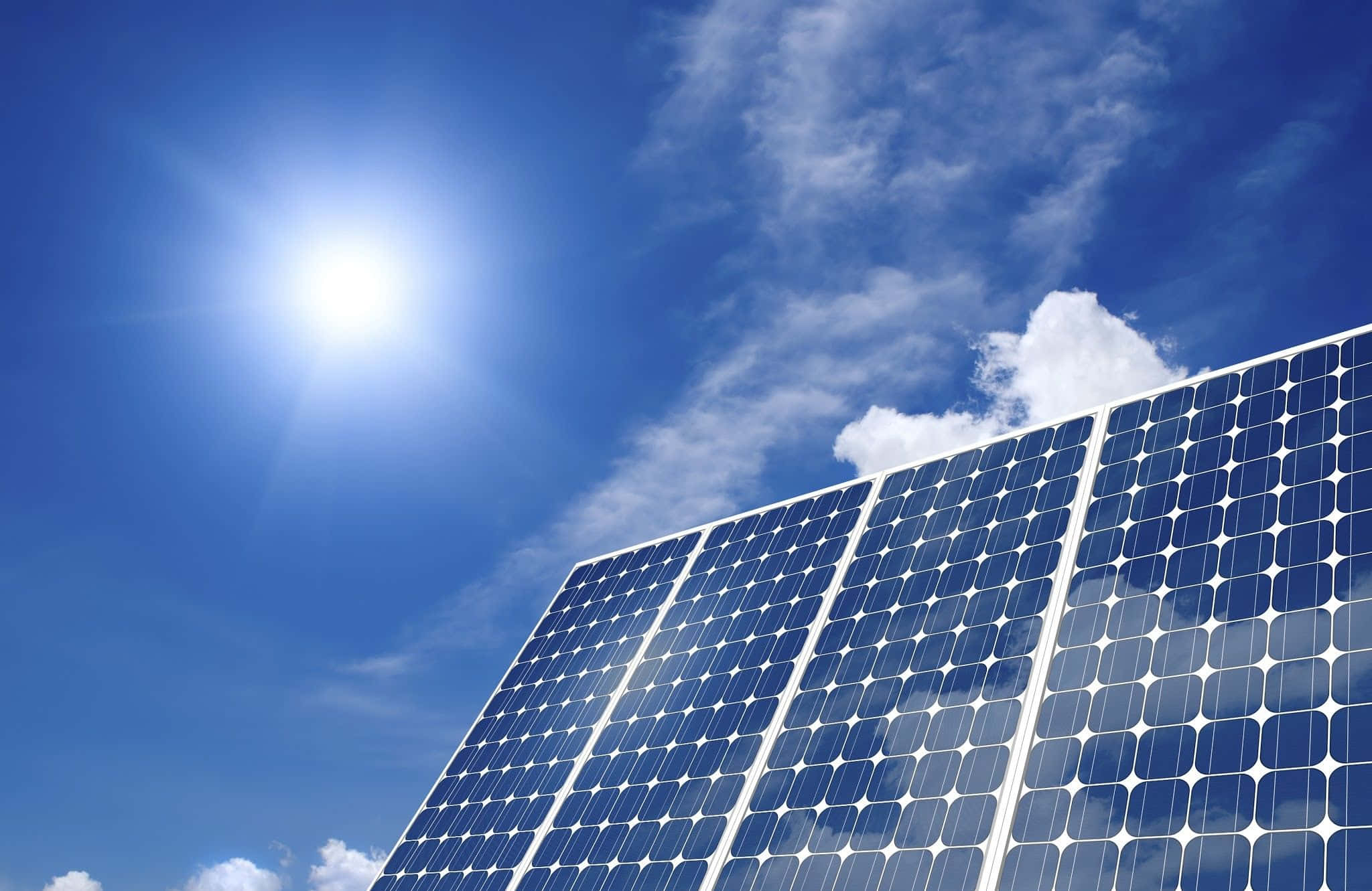 Solar Panel 桌布 壁紙 — 太陽能板在明亮的陽光下閃閃發光，背景是蔚藍的天空和縷縷白雲。