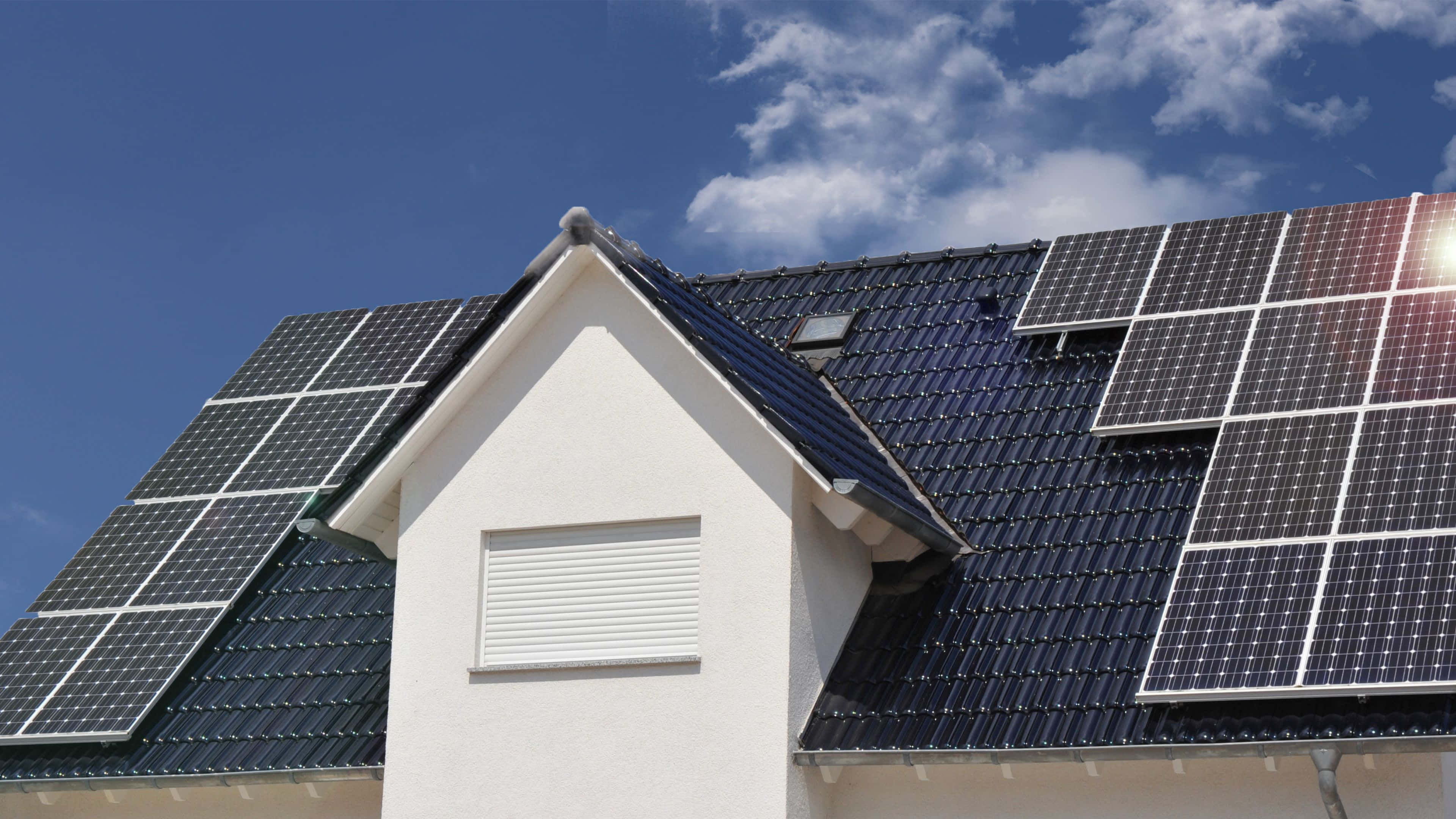 Solar Panel 桌布 壁紙 — 太陽能板在藍天白雲下的住宅屋頂上閃閃發光。