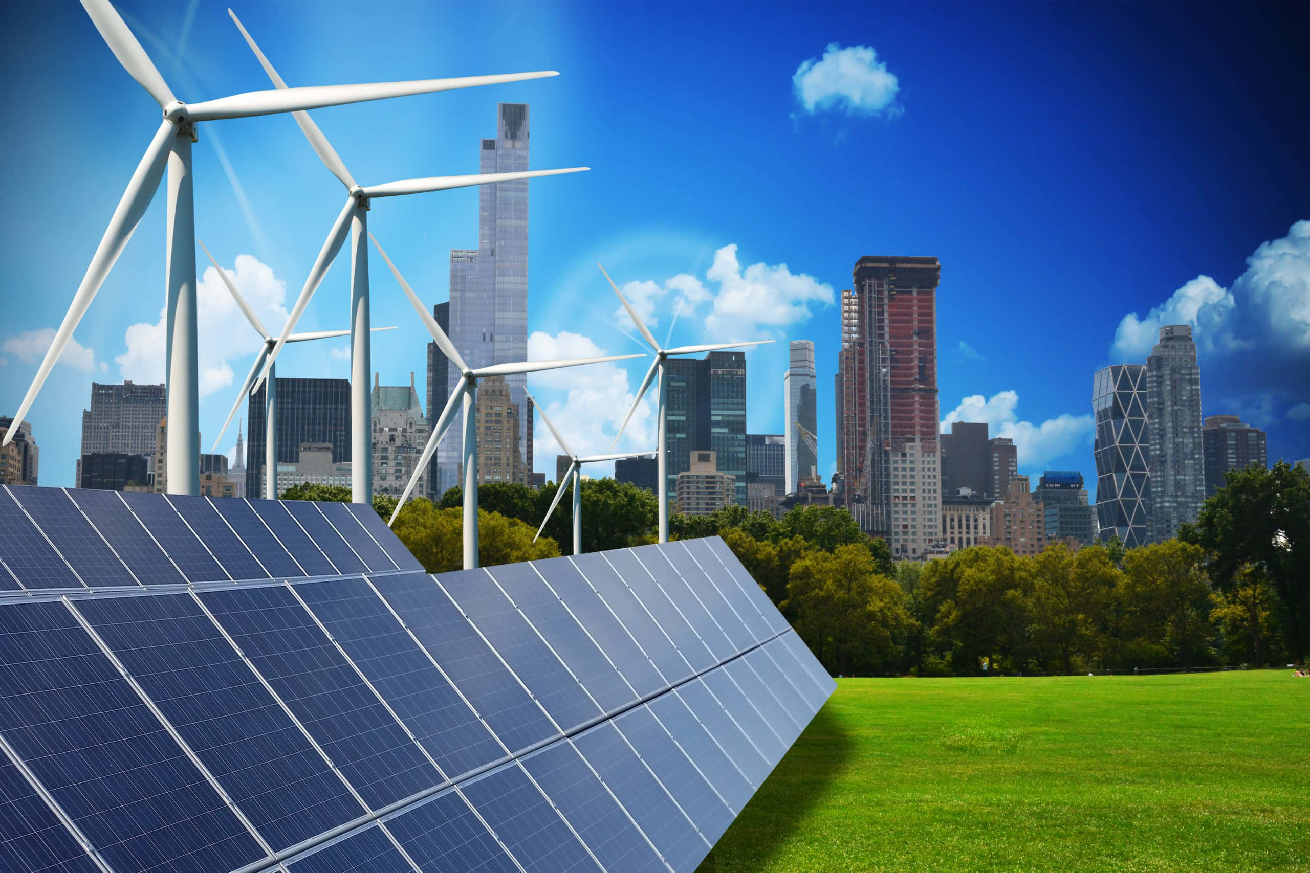 Green Technology 桌布 壁紙 — 太陽能電池板和風力渦輪機矗立在草地上，背景是現代城市天際線，天空湛藍，白雲朵朵。