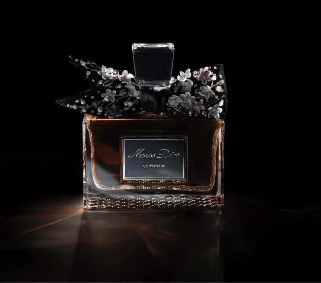 Dior 動態 桌布 壁紙 — 奢華的 Miss Dior 香水瓶，飾有寶石花卉蝴蝶結，在黑色背景下閃耀光芒。