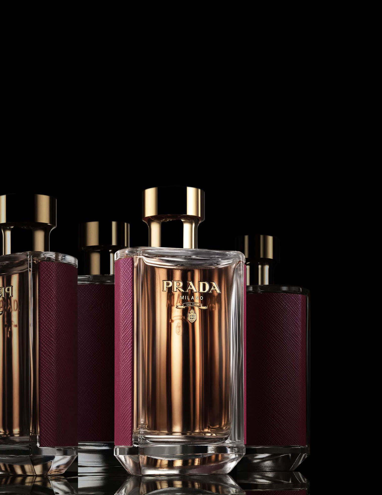 Prada 桌布 壁紙 — 奢華的Prada香水瓶，金色瓶蓋和酒紅色紋理側面，在純黑背景上閃耀。