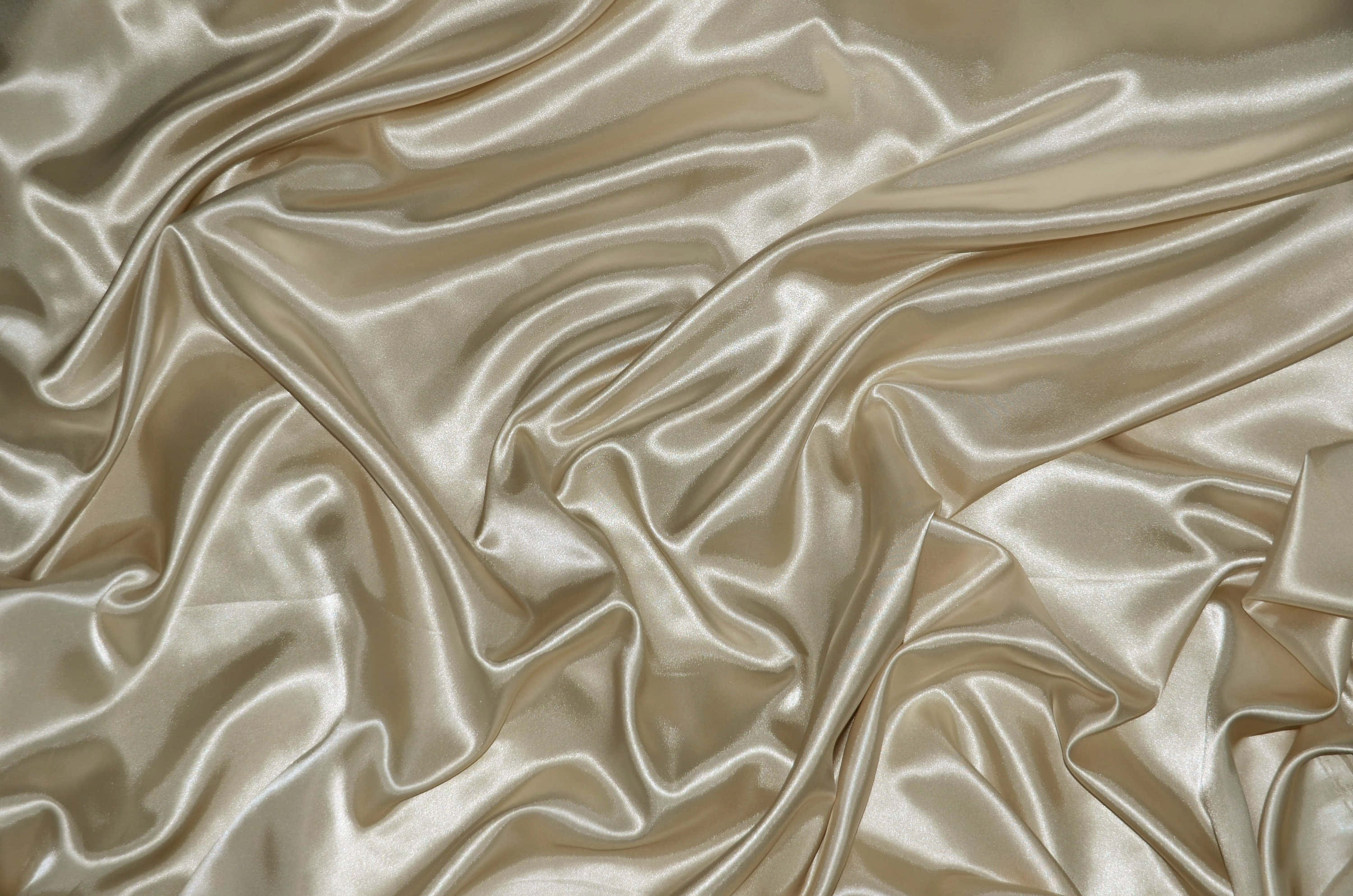Gold Silk 桌布 壁紙 — 奢華的香檳色絲綢布料，在均勻光線下呈現流暢褶皺和柔和光澤。
