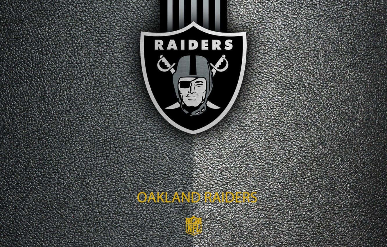 Oakland Raiders 桌布 壁紙 — 奧克蘭突襲者隊標誌以黑色和銀色呈現，背景為有紋理的深色皮革，下方有金色文字。
