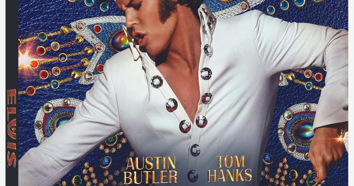 4K Elvis 桌布 壁紙 — 奧斯汀·巴特勒飾演貓王艾維斯·普里斯萊，身穿閃亮白色珠片連身衣，背景是閃爍藍色配金色裝飾。