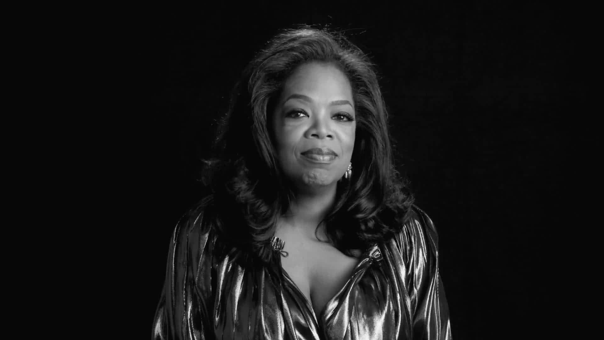 Oprah 桌布 壁紙 — 奧普拉·溫芙瑞在深色背景下穿著閃亮金屬上衣的醒目黑白肖像。