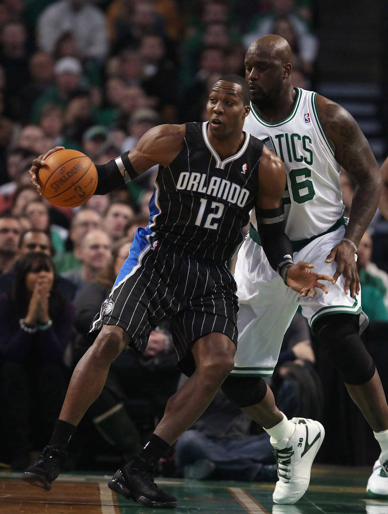 NBA 桌布 壁紙 — 奧蘭多魔術隊球員在激烈的NBA比賽中運球，同時被波士頓塞爾提克隊球員緊密防守。