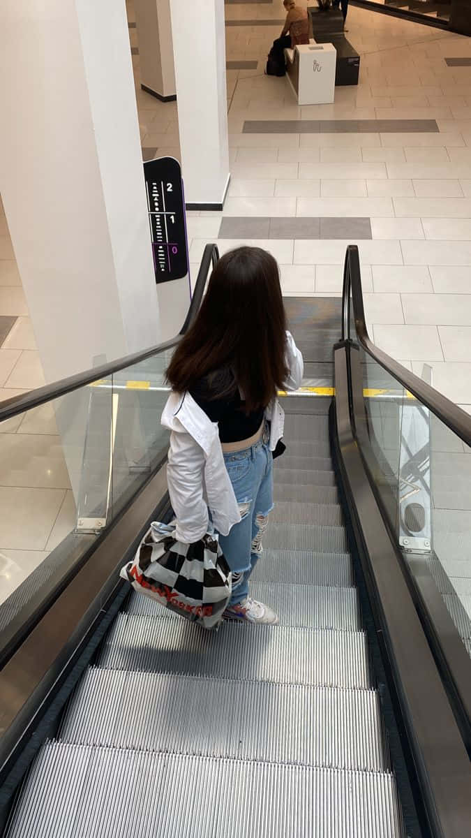 女子在百貨商場走下電扶梯 壁紙