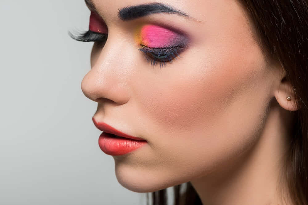 Spring Makeup 桌布 壁紙 — 女性側面特寫，在中性背景上展現大膽的粉紅色和紫色眼影以及紅唇。