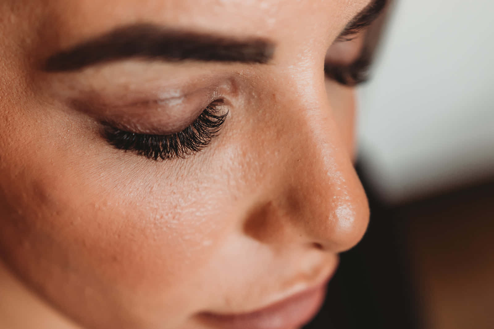 Lash 桌布 壁紙 — 女性平靜臉龐的特寫，閉上眼睛，長長的睫毛，柔和溫暖的燈光。