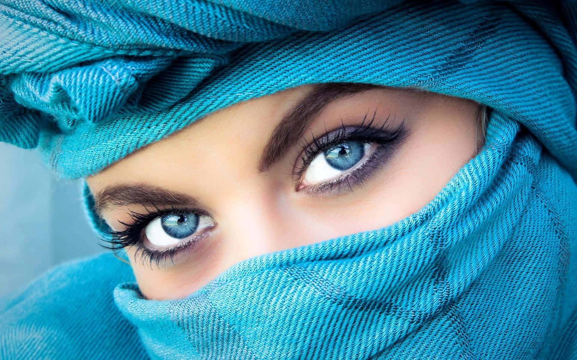 Eyes 桌布 壁紙 — 女性強烈的藍色眼睛透過充滿活力的綠松色頭巾窺視的特寫，頭巾帶有詳細的布料質感。
