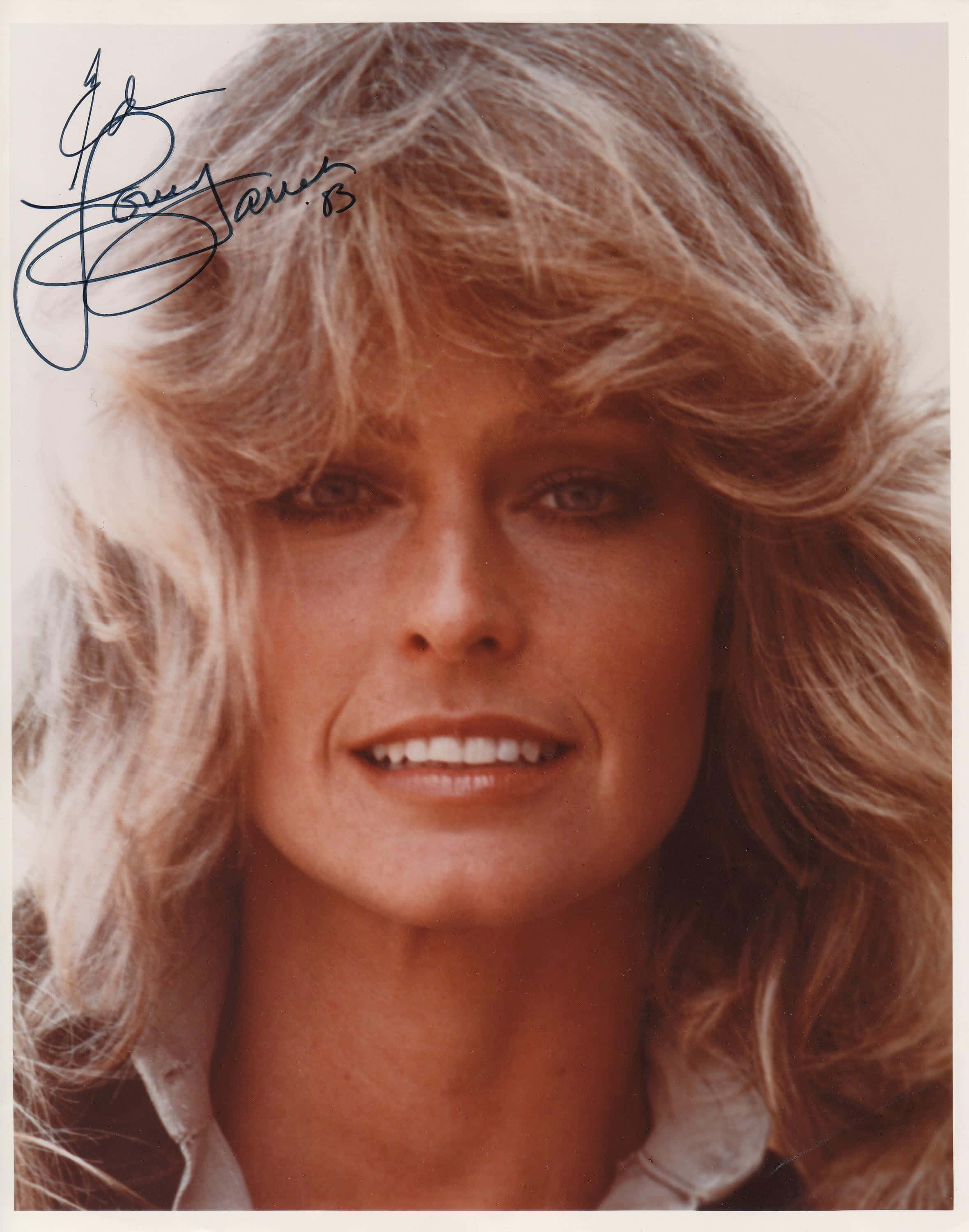 Farrah Fawcett 桌布 壁紙 — 女性特寫肖像，擁有豐盈金髮和溫暖笑容，背景為柔和米色。