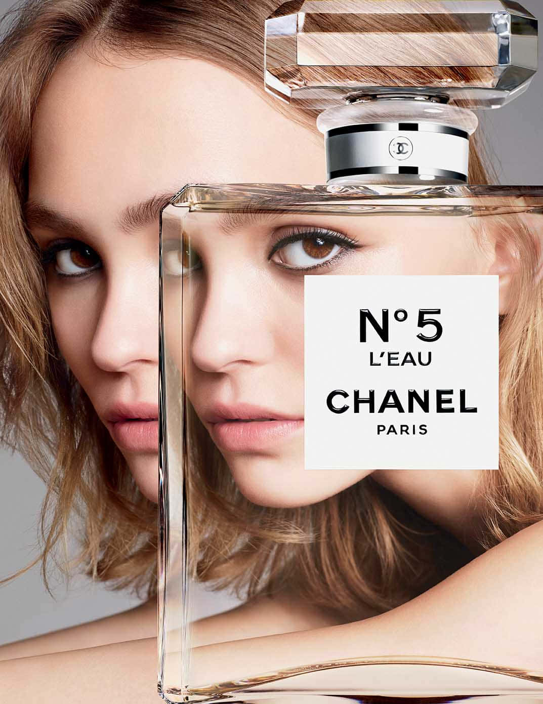 Chanel 桌布 壁紙 — 女性的臉孔與Chanel No 5 L'eau香水瓶融合，營造出超現實而優雅的視覺效果。