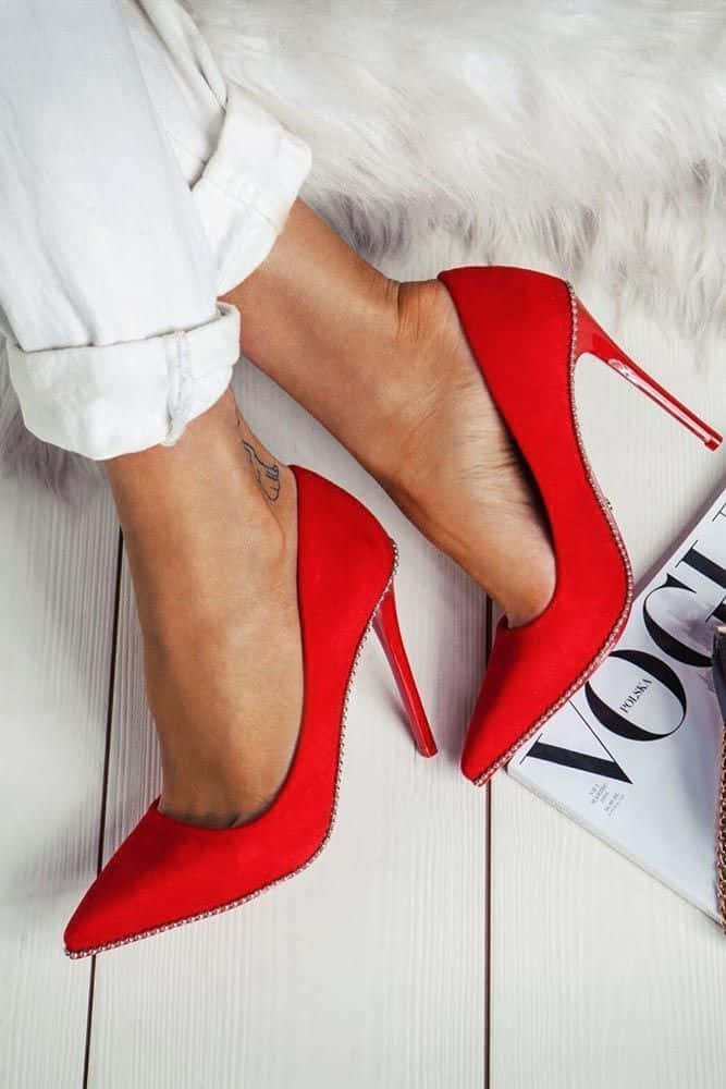 Red High Heels 桌布 壁紙 — 女性雙腳穿著大膽的紅色細高跟鞋，擱在白色木地板上，旁邊放著一本Vogue雜誌的特寫。