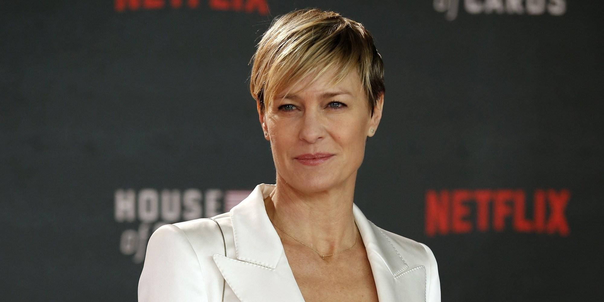 Netflix 桌布 壁紙 — 女演員羅賓·懷特在Netflix《紙牌屋》活動中自信地穿著白色西裝外套，背景為紅色標誌。