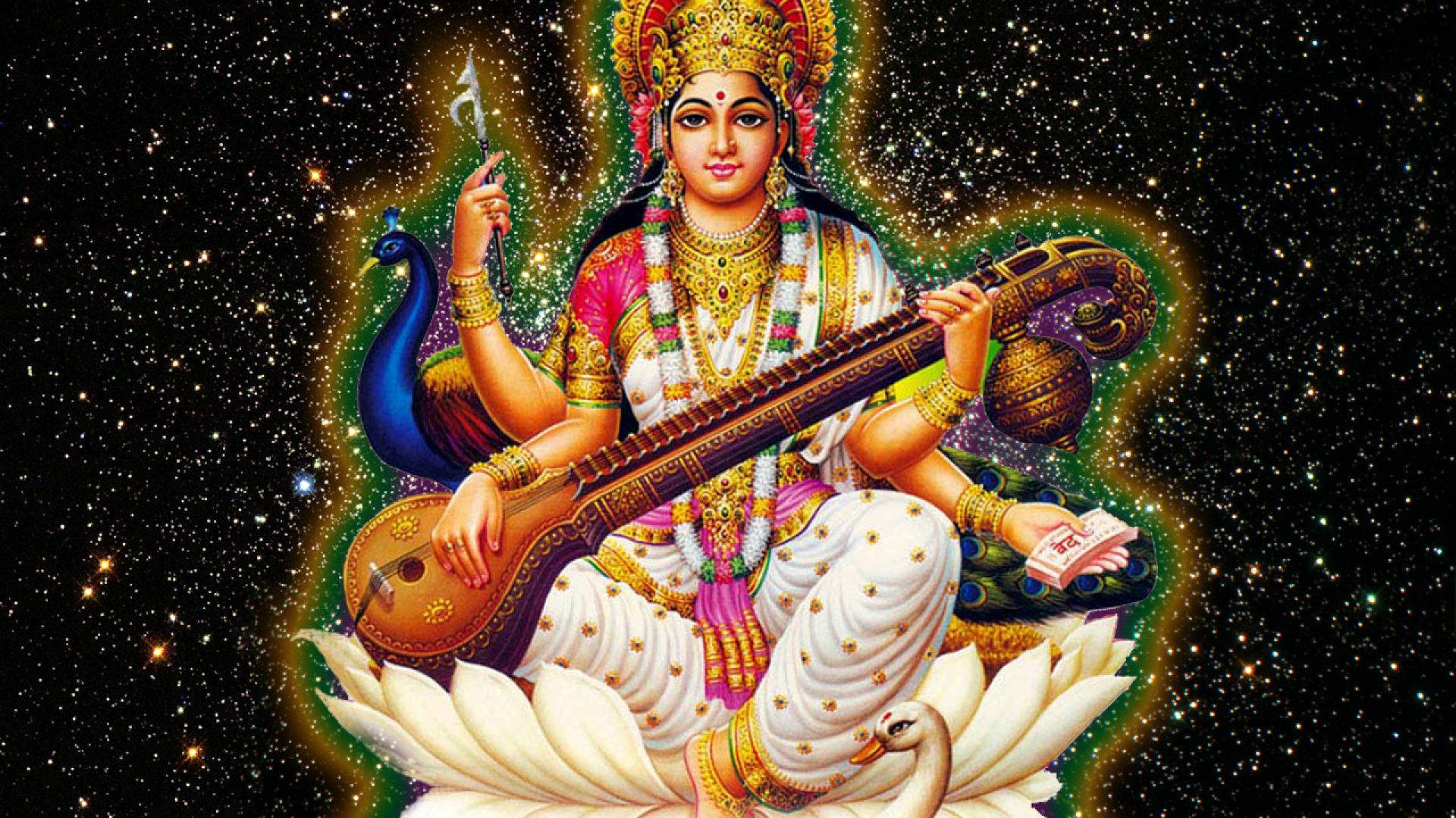 Saraswati Mata 桌布 壁紙 — 女神薩拉斯瓦蒂以金色和粉紅色裝飾，優雅地坐在白色蓮花上，手持維納琴，背景是星空宇宙。